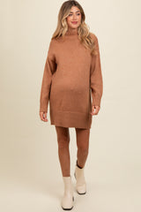 woman wearing a rust-colored maternity sweater dress with a high neck and long sleeves, highlighting her baby bump