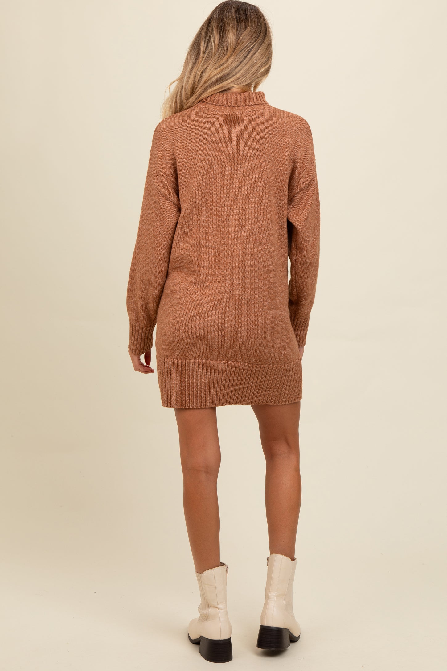 woman wearing a brown maternity sweater dress with a ribbed hem and a cowl neck, showing a subtle back view