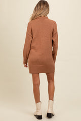 woman wearing a brown maternity sweater dress with a ribbed hem and a cowl neck, showing a subtle back view