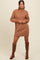woman wearing a brown knitted turtleneck sweater dress with long sleeves and knee-high brown boots