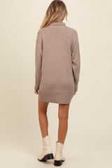 woman wearing a taupe knitted maternity sweater dress with a turtle neck and ribbed hem, shown from the back