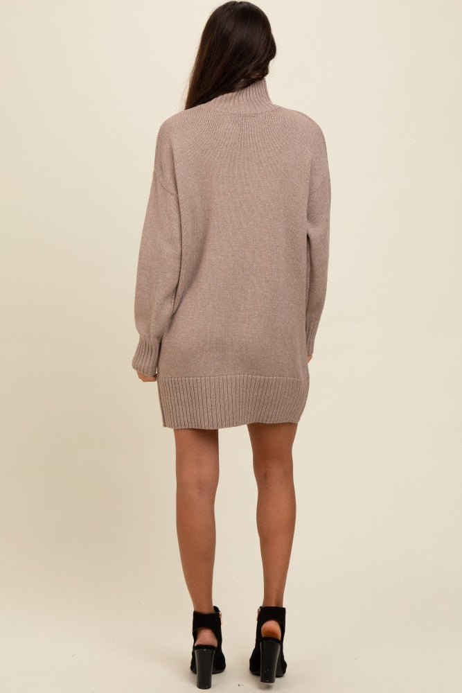 woman wearing a taupe oversized sweater dress with a high neck and long sleeves, showing the back view