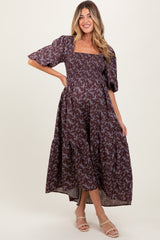 woman wearing a floral print maternity maxi dress with smocked bodice and puff sleeves, highlighting her baby bump