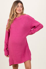 woman wearing a bright pink oversized maternity sweater dress with a relaxed fit and long sleeves