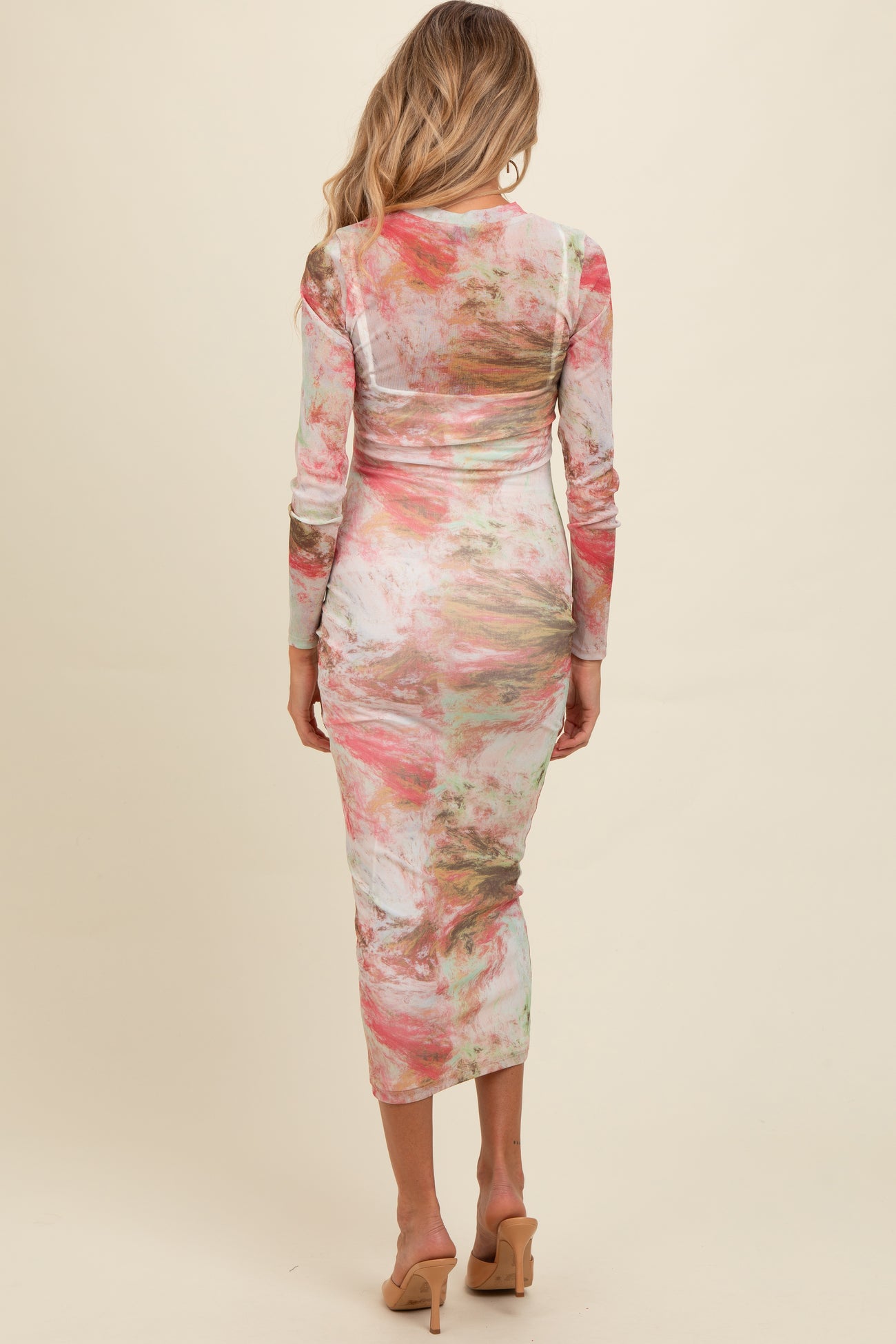 woman wearing a colorful long sleeve maternity dress with a fitted silhouette and a midi length