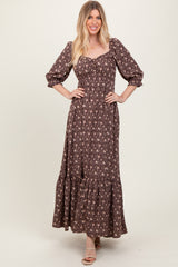 woman wearing a brown floral maxi dress with puff sleeves and a tiered skirt