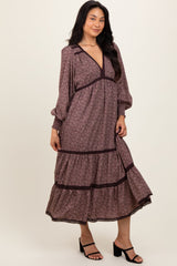 woman wearing a floral print midi dress with long sleeves and a tiered skirt, standing in a relaxed pose