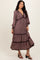 woman wearing a floral print midi dress with long sleeves and a tiered skirt, standing in a relaxed pose
