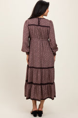woman wearing a maroon floral maxi dress with long sleeves and tiered ruffles, seen from the back