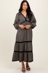 woman wearing a black floral long sleeve maxi dress with a tiered skirt and a v-neckline