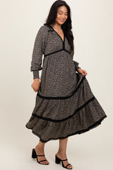 woman wearing a dark floral long sleeve maxi dress with a v-neck and ruffled hem, styled with black strappy heels