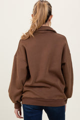 woman wearing a brown oversized maternity sweatshirt with a relaxed fit and long sleeves, showing her pregnant belly from the back