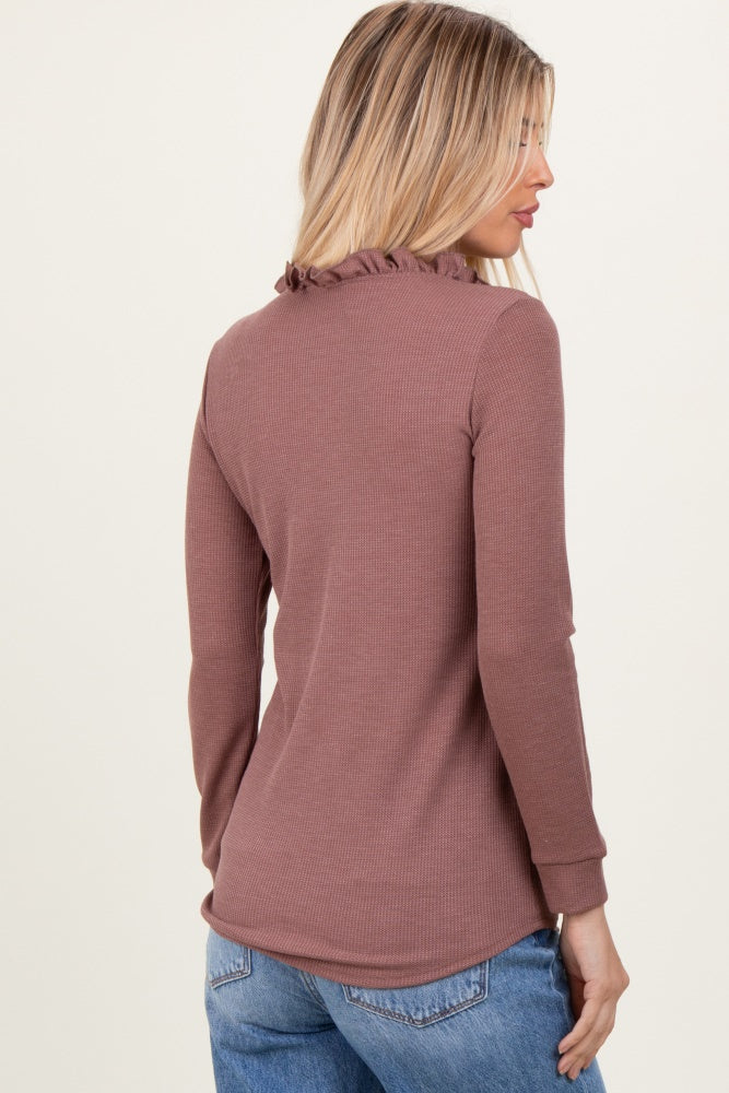 woman wearing a dusty rose long sleeve ribbed top with ruffled neckline and back detail, paired with jeans