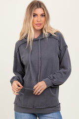 woman wearing a gray striped long sleeve oversized hoodie with a front pocket and drawstring hood