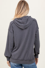 woman wearing a dark gray ribbed hoodie with a relaxed fit and a hood, facing away from the camera
