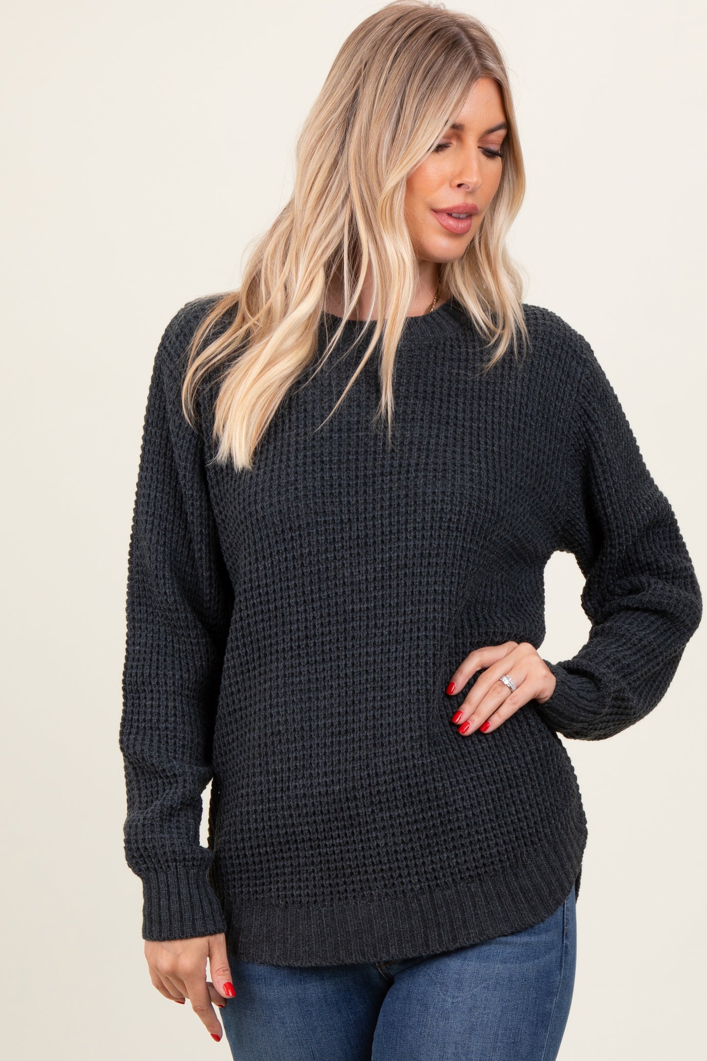 woman wearing a dark gray textured oversized sweater with long sleeves and a relaxed fit