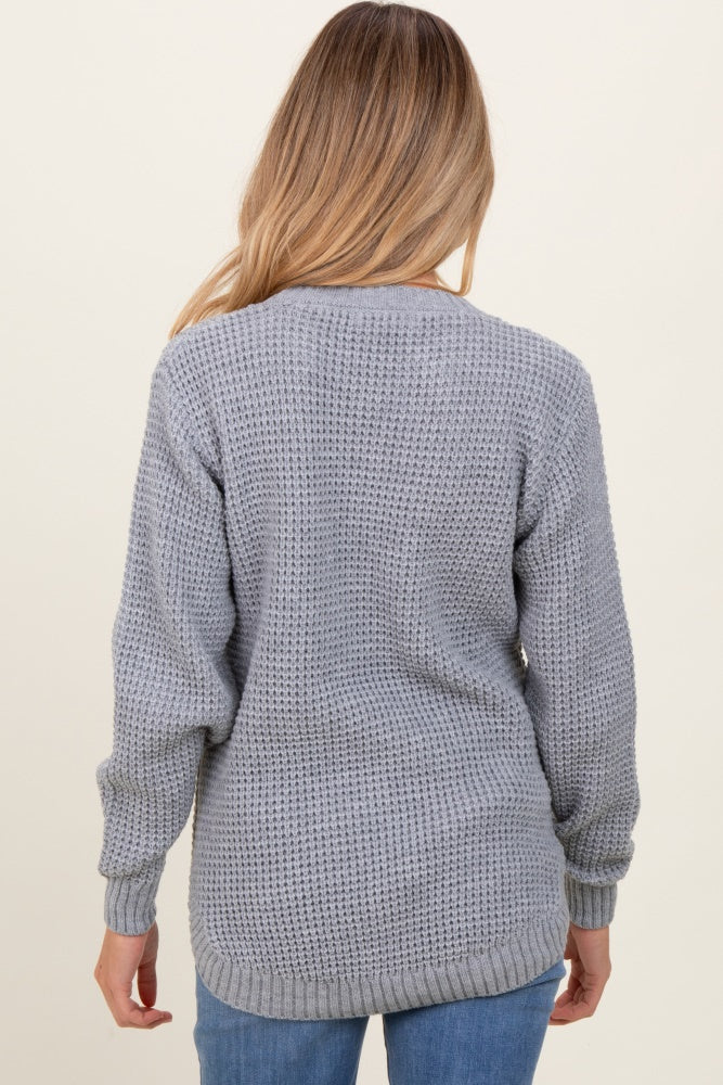 woman wearing a gray knit maternity sweater with a relaxed fit and long sleeves, viewed from the back