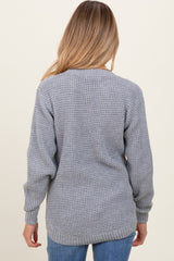 woman wearing a gray knit maternity sweater with a relaxed fit and long sleeves, viewed from the back