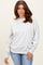 woman wearing a light grey oversized sweatshirt with dropped shoulders and long sleeves, paired with blue jeans