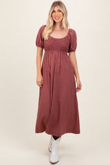woman wearing a burgundy striped maxi dress with a smocked bodice and puff sleeves, paired with white ankle boots