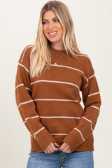 woman wearing a brown striped sweater with white lines and casual blue jeans