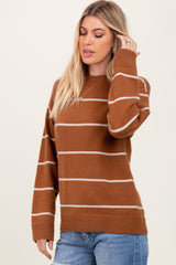 woman wearing a brown and cream striped oversized sweater with long sleeves and a relaxed fit