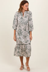 woman wearing a floral print midi dress with puff sleeves and a tiered hem, standing against a plain background