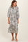 woman wearing a floral print midi dress with puff sleeves and a tiered hem, standing against a plain background