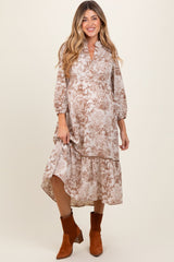 woman wearing a floral patterned maternity dress with a high-low hem and 3/4 sleeves, showing her baby bump