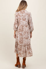 woman wearing a floral print maternity dress with three-quarter sleeves and a tiered skirt, viewed from the back