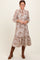 woman wearing a brown floral midi dress with a button-down front and ruffled hem, paired with brown knee-high boots
