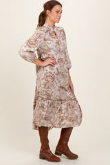 woman wearing a long sleeve brown and cream floral print midi dress with a tiered skirt and paired with brown knee-high boots