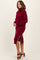 woman wearing a burgundy turtleneck sweater dress with side slits and long sleeves