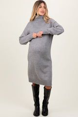 woman wearing a cozy gray turtleneck maternity sweater dress with a visible baby bump