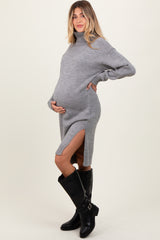 woman wearing a grey turtleneck maternity dress with side slits and holding her baby bump
