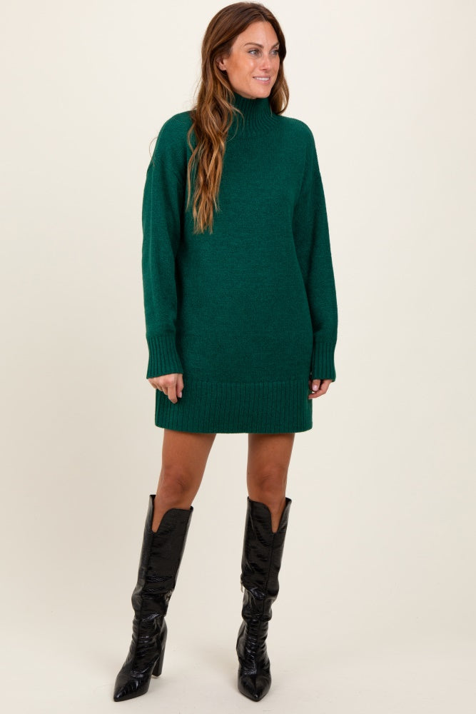 woman wearing a green turtleneck sweater dress with long sleeves and knee-high black boots