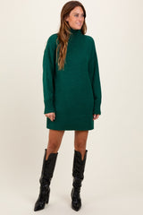 woman wearing a green turtleneck sweater dress with long sleeves and knee-high black boots