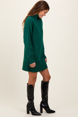 woman wearing a green oversized sweater dress and black knee-high heeled boots