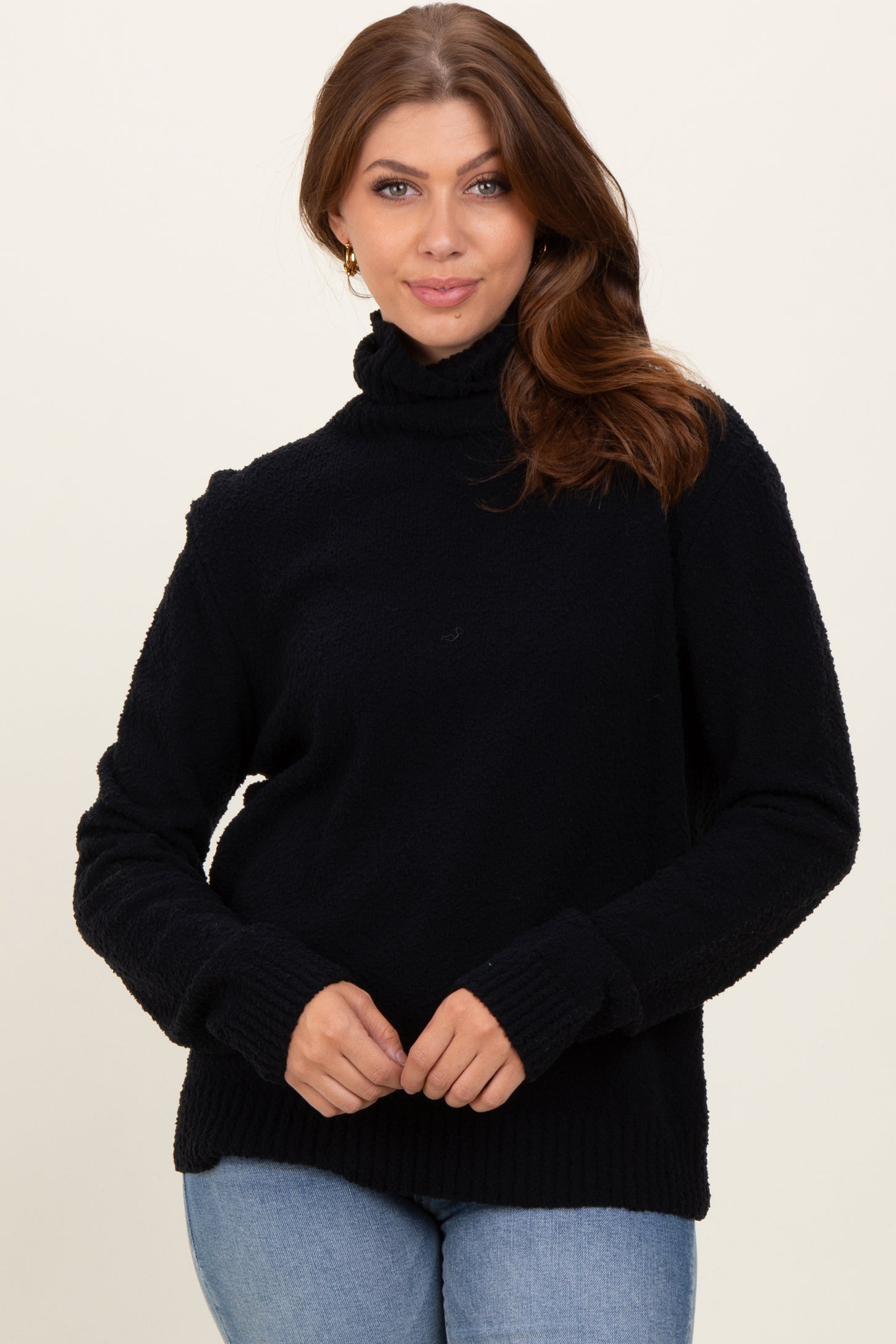 woman wearing a black turtleneck sweater with ribbed cuffs and hem, paired with light blue jeans
