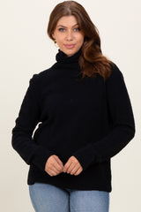 woman wearing a black turtleneck sweater with ribbed cuffs and hem, paired with light blue jeans