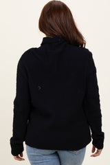 woman wearing a black fuzzy turtleneck sweater, viewed from the back, paired with light blue jeans