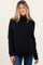 woman wearing a black turtleneck maternity sweater and showing her baby bump with a relaxed fit