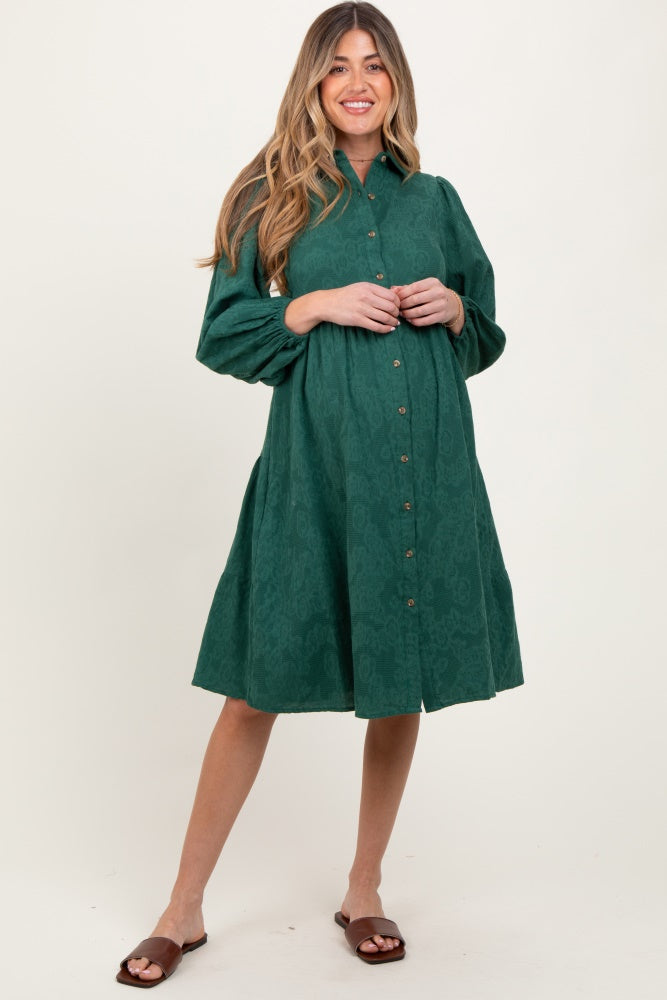 woman wearing a dark green long sleeve button-up maternity dress with a flared skirt and visible baby bump