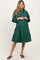 woman wearing a dark green long sleeve button-up maternity dress with a flared skirt and visible baby bump
