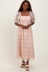 woman wearing a pink floral lace maxi dress with puff sleeves and a square neckline