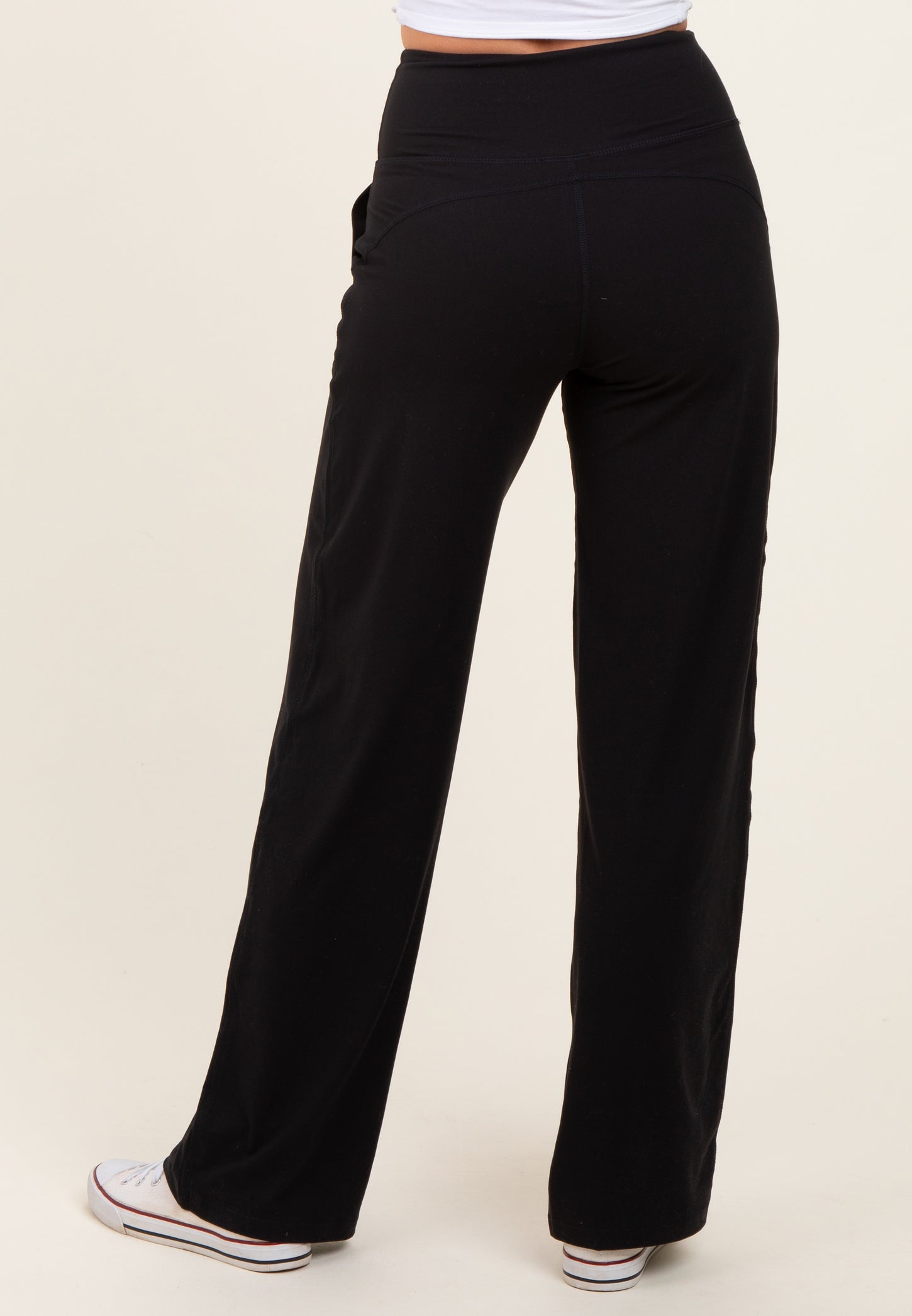 woman wearing black wide-leg pants with a high waistband and side pockets, viewed from the back