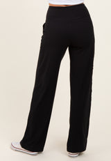 woman wearing black wide-leg pants with a high waistband and side pockets, viewed from the back