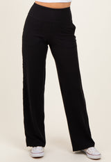 woman wearing black wide-leg pants with pockets and an elastic waistband