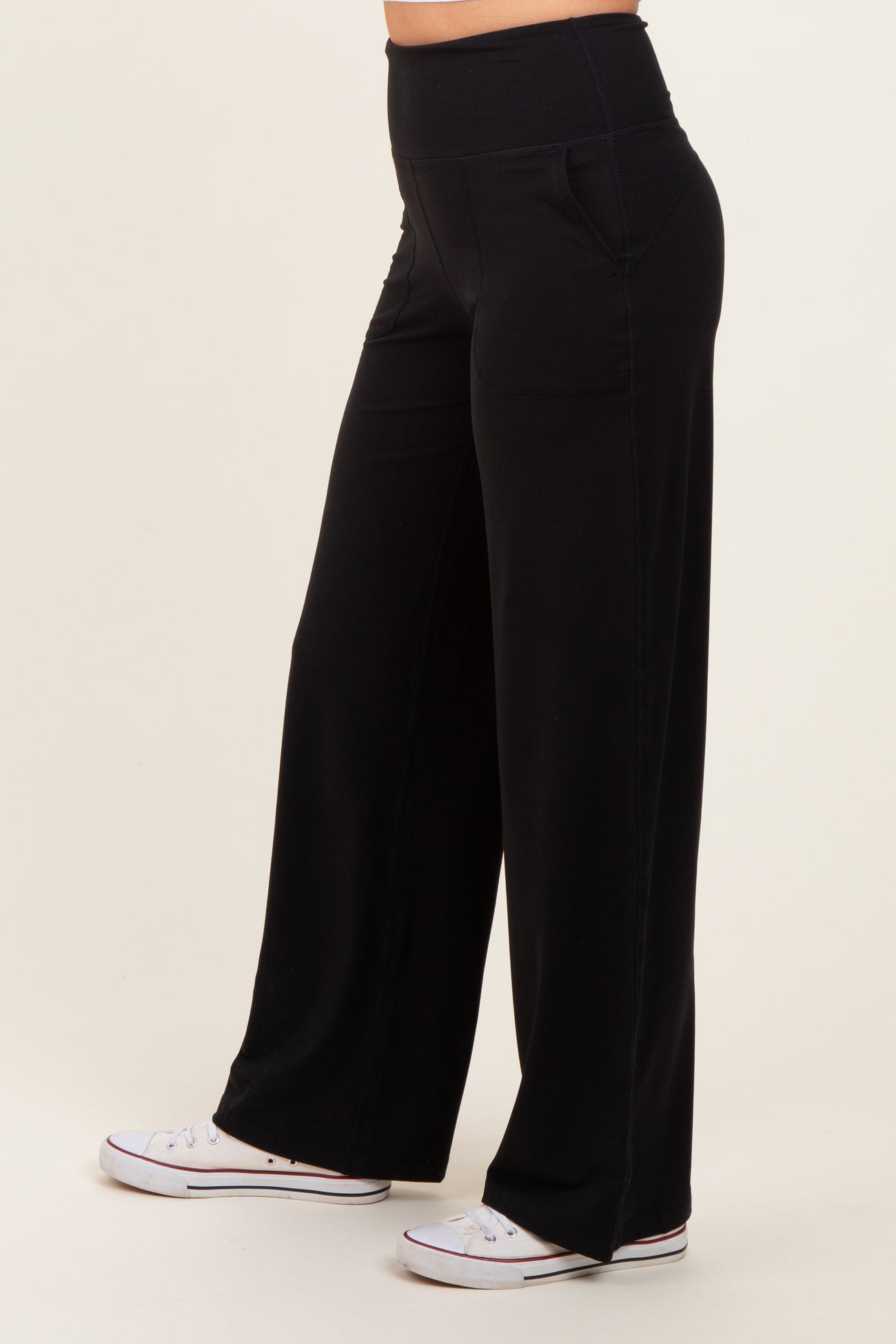 woman wearing black wide-leg pants with pockets and a high waistband