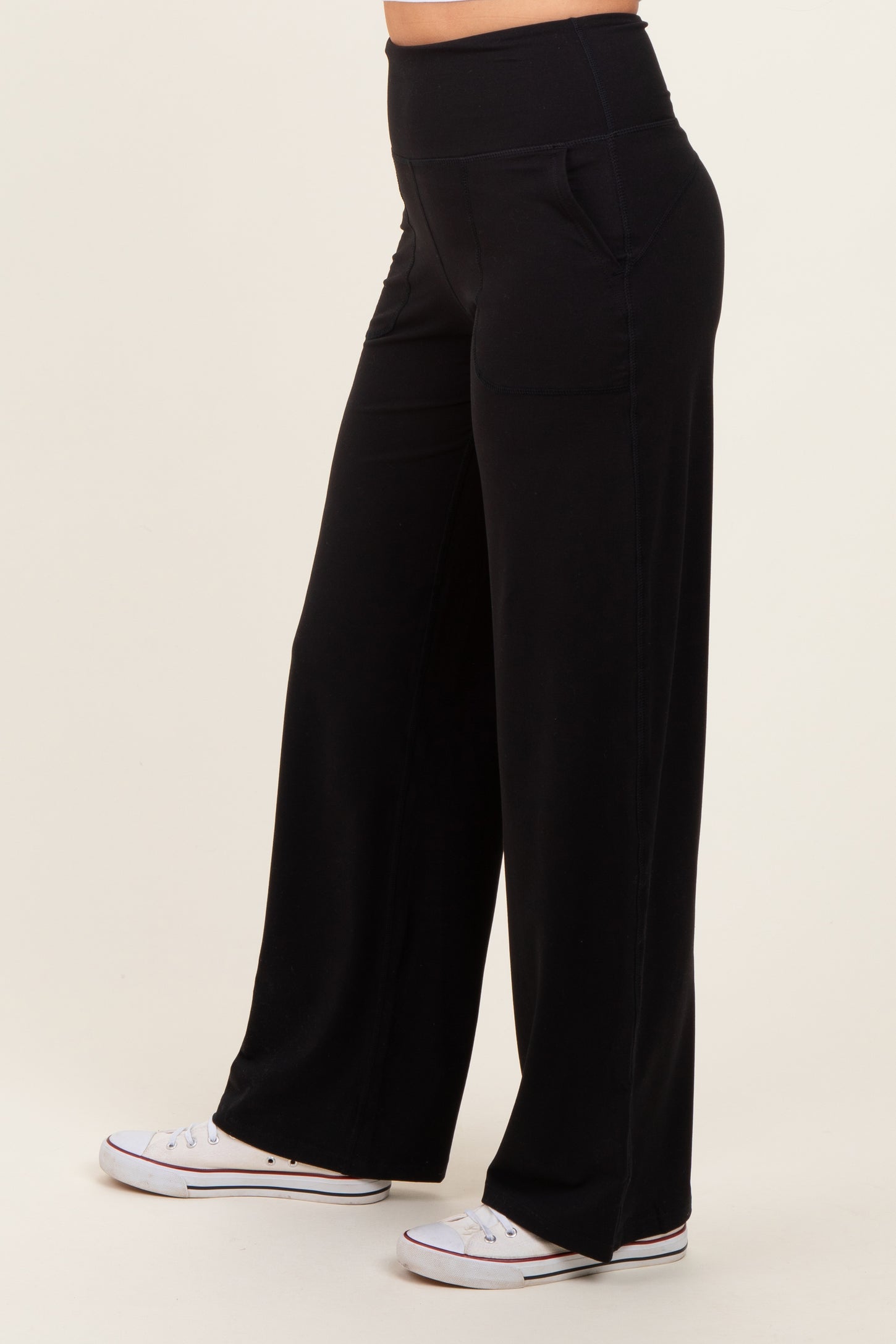 woman wearing black wide-leg pants with pockets and a high waistband